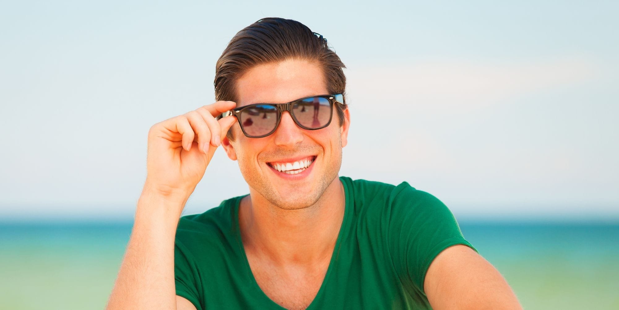 Man Smiling Holding His Sunglasses